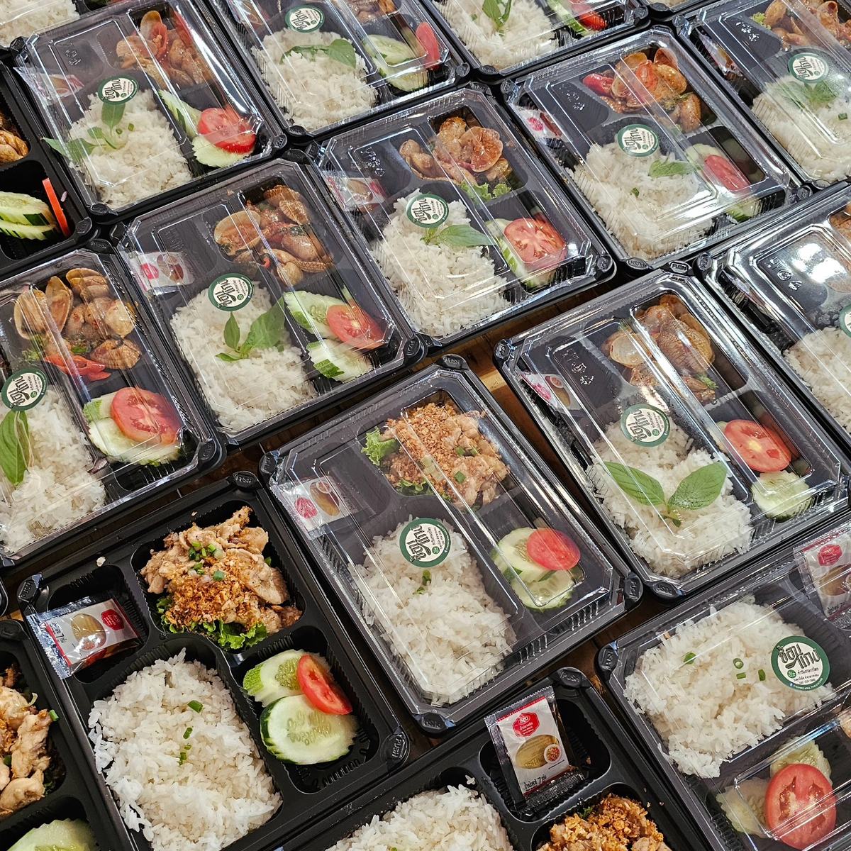 ข้าวกล่องช้อนแกงจัดเรียงเป็นแถวก่อนแพ็กส่ง